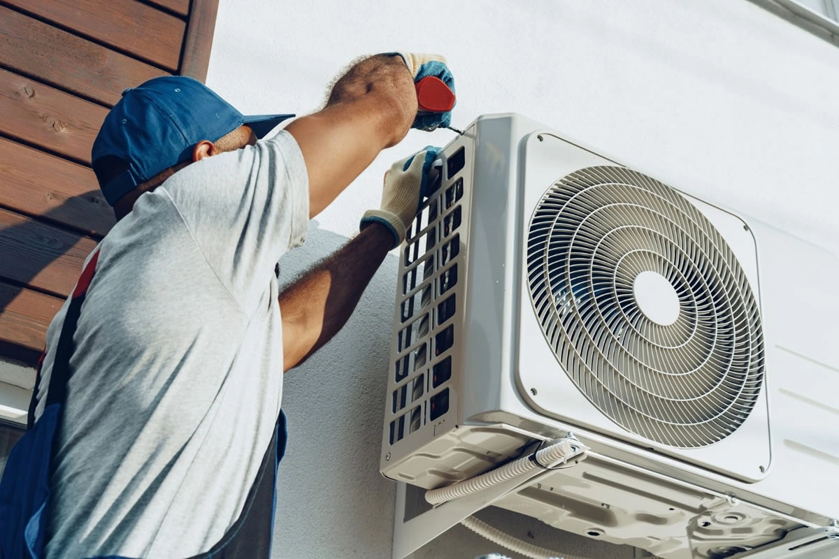 Técnico instalando condensadora de ar condicionado na área externa em Imperatriz
